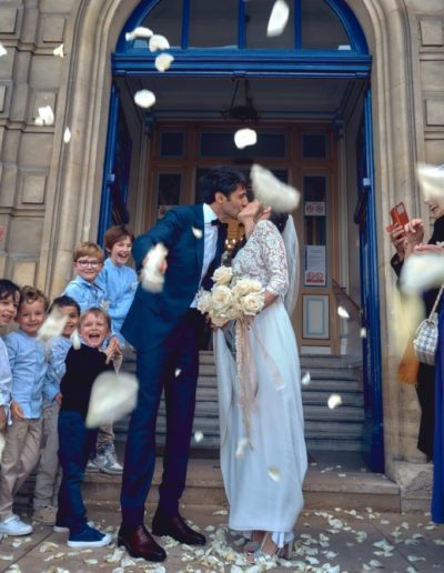 Les mariés sont acclamés par leurs invités et ils lancent des pétales