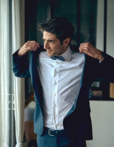 Le marié enfile son costume pour aller à la mairie